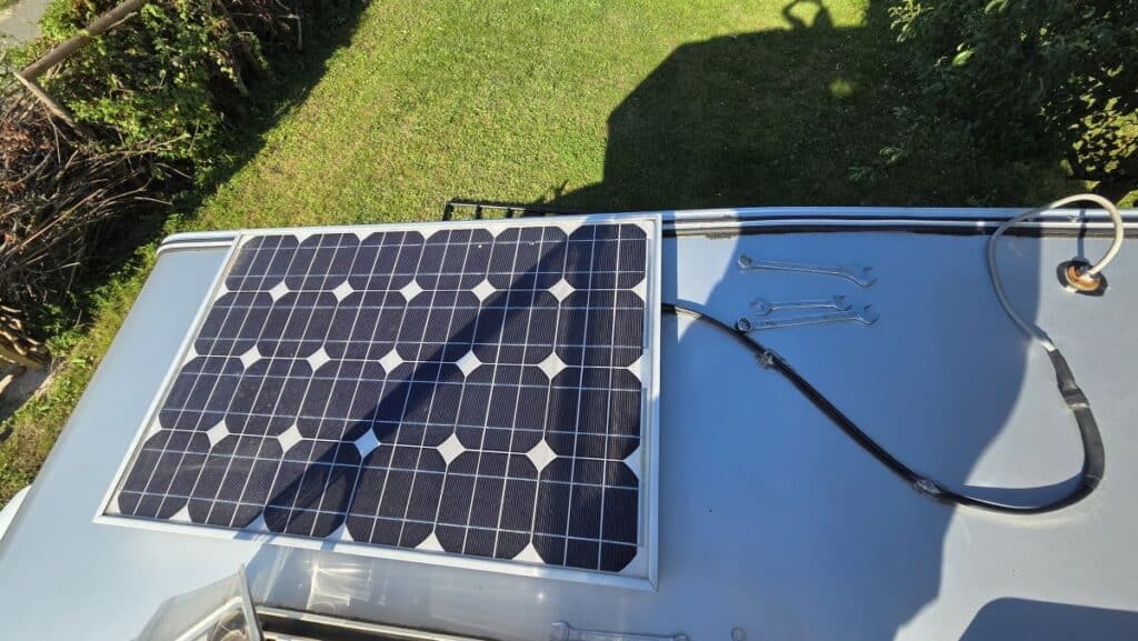 Altes 50 Wp Solarmodul auf dem Dach der Wohnkabine, daneben Gabelschlüssel und das alte Solarkabel