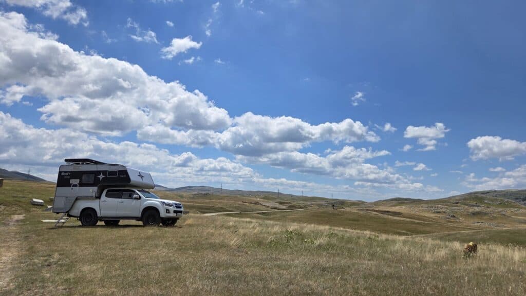 Isuzu D-Max mit Nordstar Wohnkabine beim Freistehen auf einer weiten Hochebene am Balkan bei Tageslicht