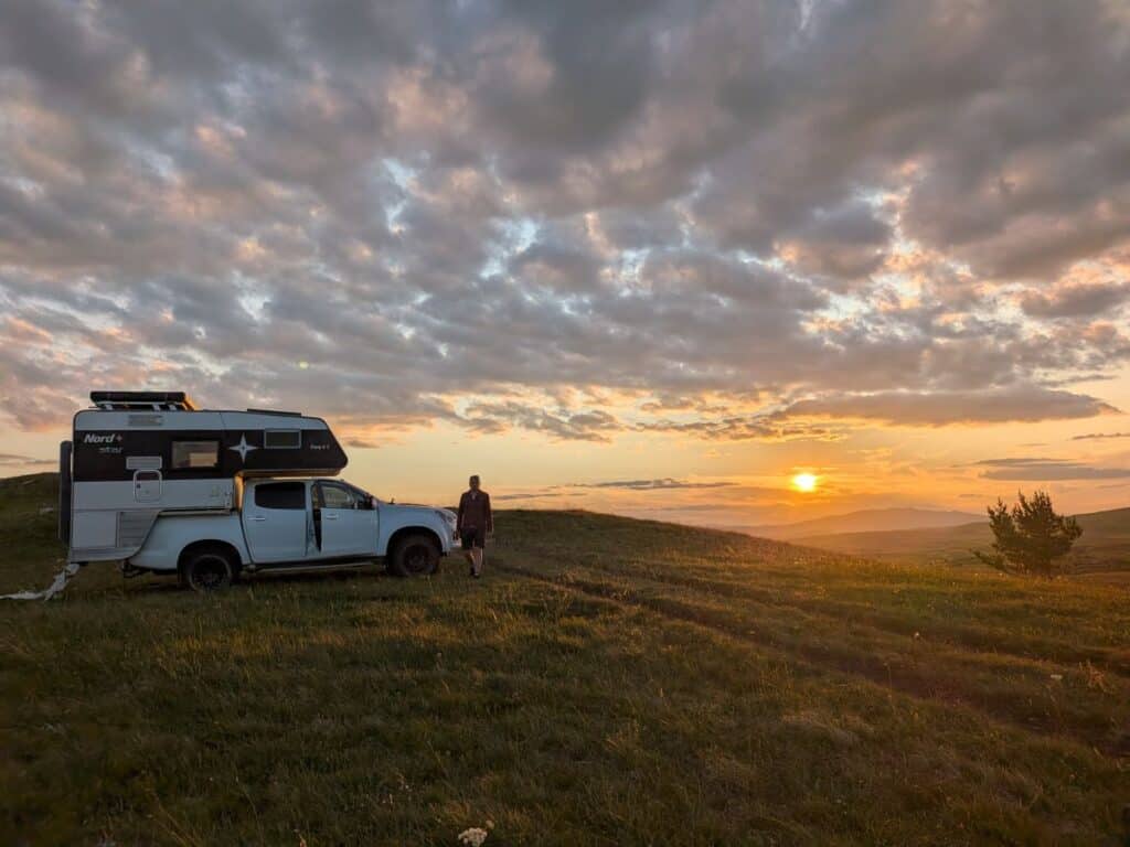 Isuzu D-Max mit Nordstar Wohnkabine beim Freistehen auf einem Hochplateau auf dem Balkan bei Sonnenuntergang