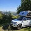 Pickup Camper kaufen: Weißer Isuzu D-Max Double Cab mit grauer Nordstar Camp 6S Wohnkabine auf Aussichtspunkt