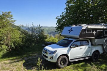 Pickup Camper kaufen: Weißer Isuzu D-Max Double Cab mit grauer Nordstar Camp 6S Wohnkabine auf Aussichtspunkt