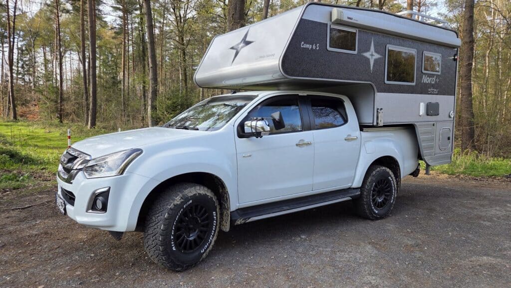 Isuzu D-Max Double Cab mit Nordstar Camp 6S Wohnkabine kaufen, seitliche Ansicht im Wald