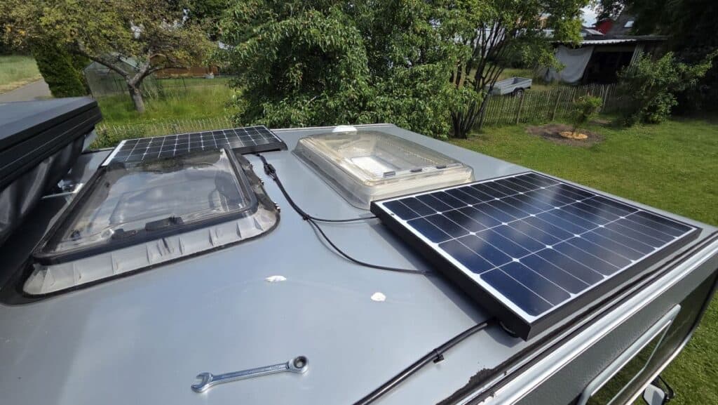 Zwei parallel geschaltete Solarmodule auf dem Dach der Wohnkabine, verbunden über MC4-Y-Stecker, Kabel mit Montagesockeln befestigt