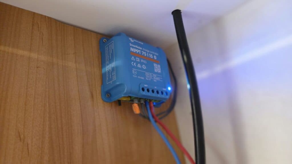 Victron SmartSolar MPPT 75/15 Solarladeregler an der Schrankwand der Wohnkabine, angeschlossen über rote und blaue Kabel