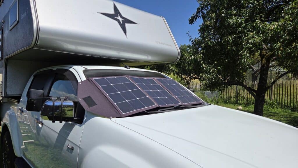 Aufgeklappte Wattstunde SOLA Ease Solartasche mit 140 Wp auf der Motorhaube des Pickup-Campers mit Nordstar Wohnkabine